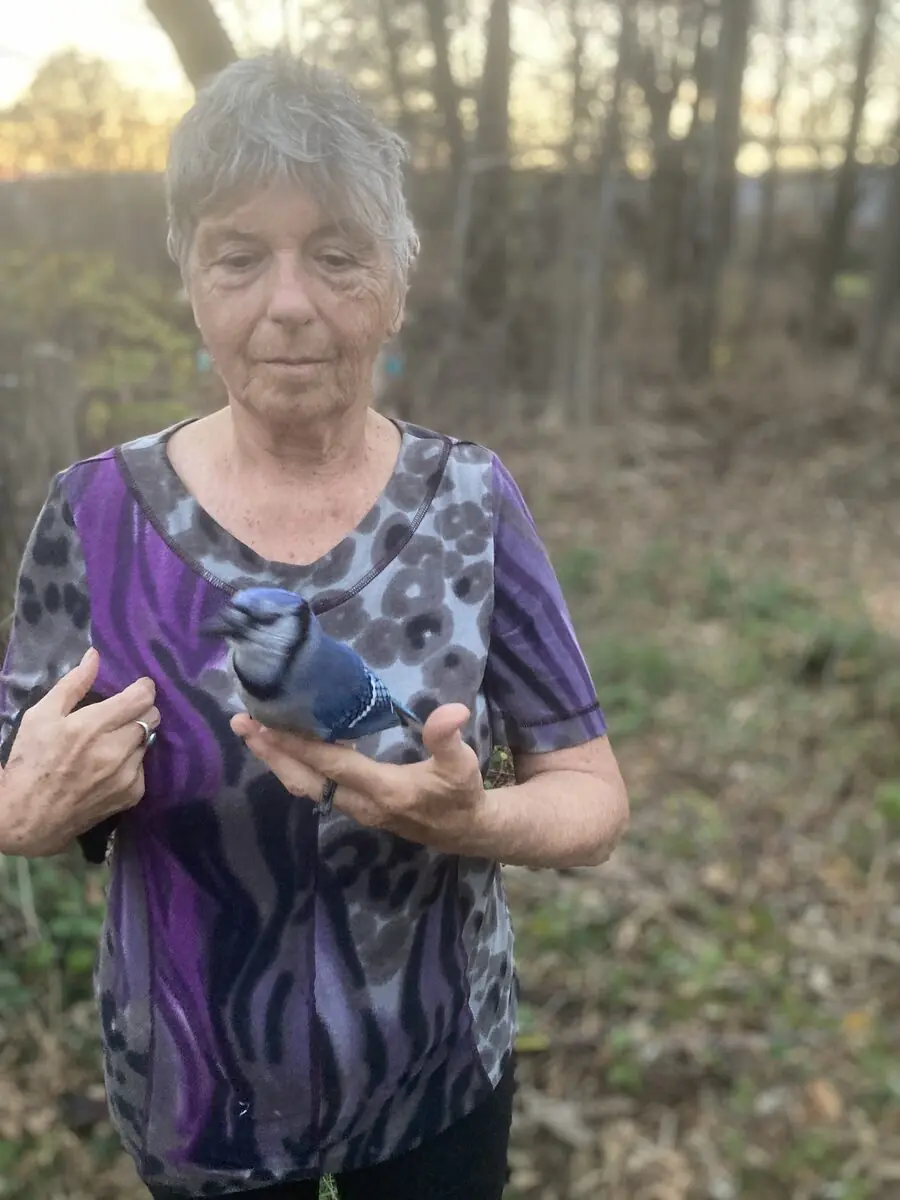 An elder smiling outdoors at dusk