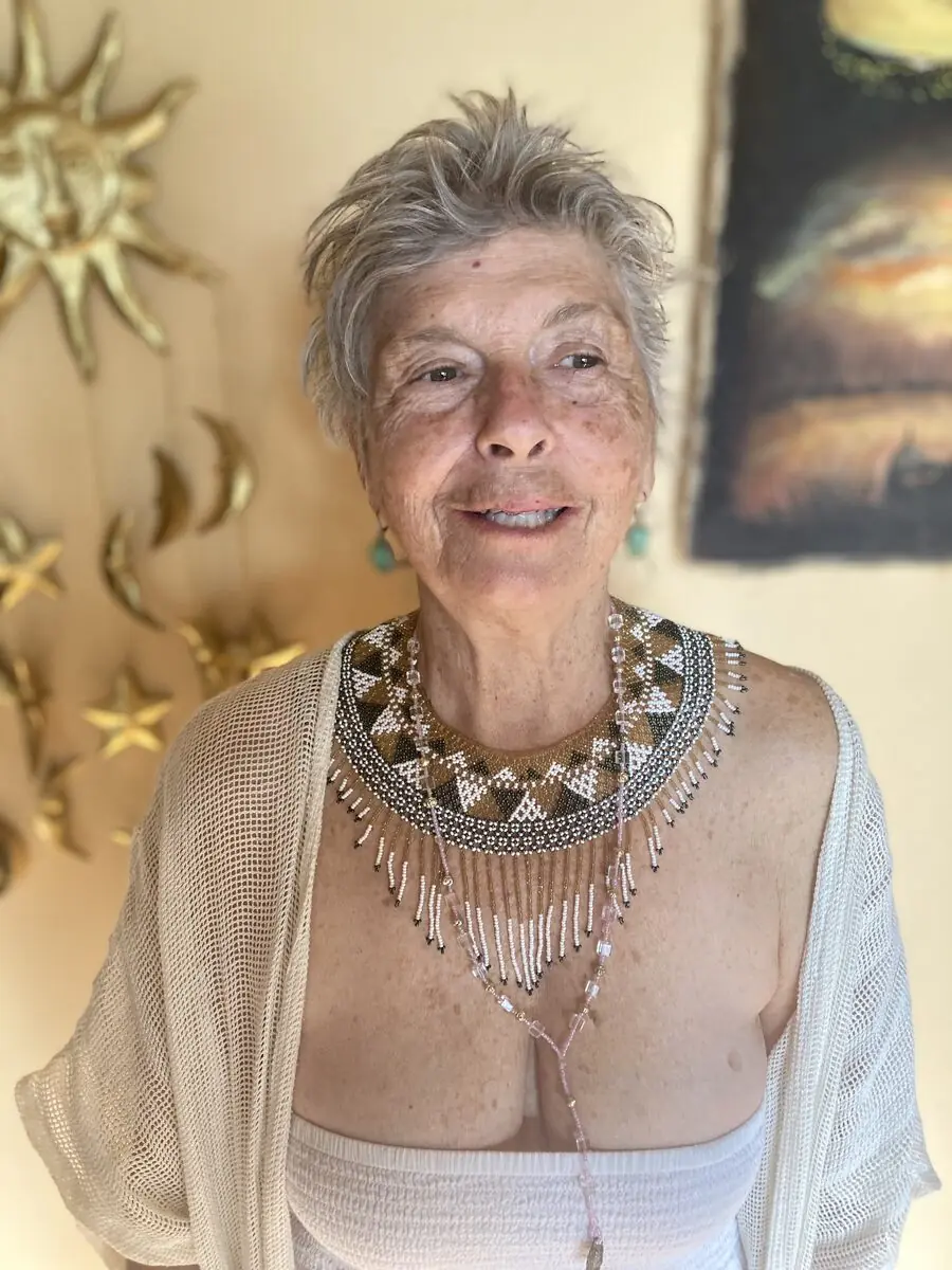 A warm portrait of an elder wearing a beaded necklace