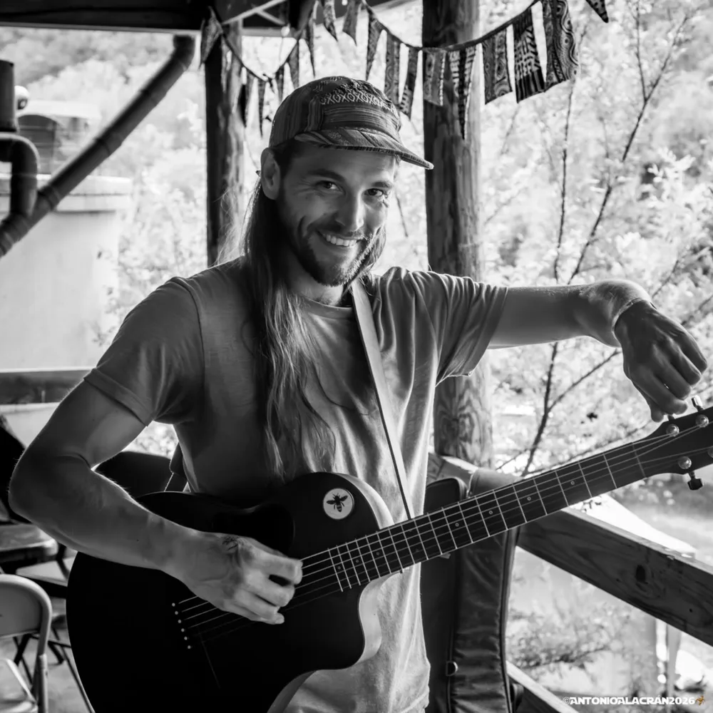 Josh Hines holding a guitar, black and white portrait