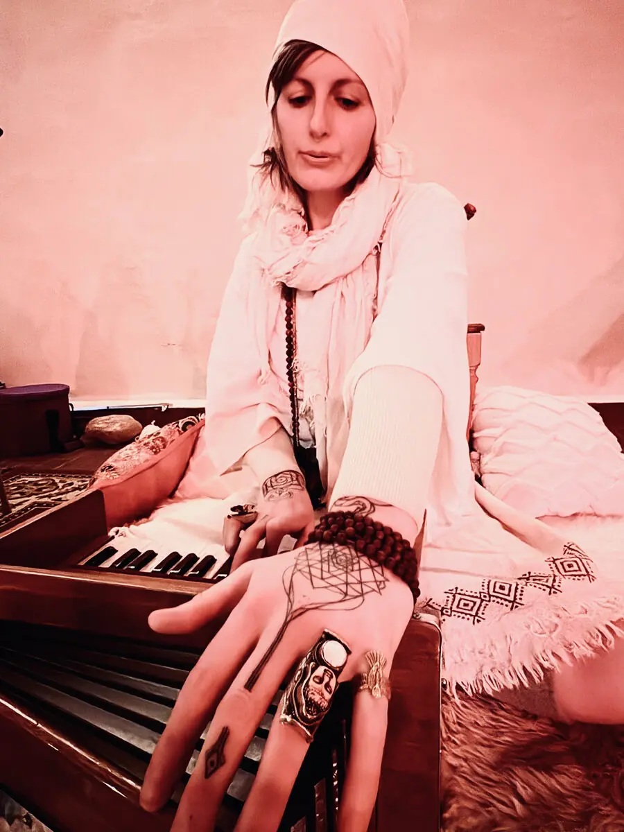 Warm candlelit gathering with harmonium and song